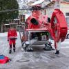 Helfer stehen an einem Rettungshubschrauber.