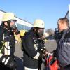 Die Atemschutz-Träger der Feuerwehr Unterthürheim holen die Utensilien der Roma-Mitarbeiter aus der verqualmten Halle.