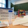 Ein komplettes, unbenutztes Set des Lollitests steht im Klassenzimmer einer Grundschule. Die komplette Umstellung der Corona-Tests dauert auch im Landkreis Neu-Ulm noch einige Tage.