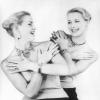 Reich behängt mit Schmuck lachen sich die Zwillinge Alice und Ellen Kessler an - aufgenommen am 1956 im Pariser Lido.