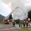 Feurwehrleute löschen die brennende Lagerhalle bei Buchenberg im Allgäu.