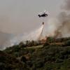 Ein Hubschrauber versucht mit Wasser ein Feuer auf Gran Canaria zu löschen. Der Waldbrand in den Bergen von Gran Canaria ist nach Behördenangaben schwächer geworden. 