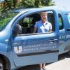 Rosmarie Regler, Mitarbeiterin der Poststelle der KU, mit dem neuen elektrischen Postauto.  	