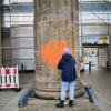 Eine Klimaaktivistin beschmiert das Brandenburger Tor mit oranger Farbe.