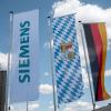 Das Siemens-Logo weht neben der bayerischen Flagge und der Deutschlandflagge auf dem Firmengelände des Unternehmens.