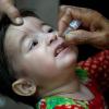Ein Gesundheitshelfer verabreicht einem Kind einen Polio-Impfstoff.