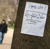 Ein Zettel warnt in einem Park in Berlin vor ausgelegten Giftködern.