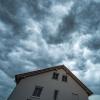 Dunkle Gewitterwolken ziehen in Straubing in Bayern über ein Haus hinweg.