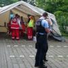 Polizisten stehen in Halberstadt (Sachsen-Anhalt) vor einem Rot-Kreuz-Zelt. Es steht neben einer Sporthalle, in der Asylsuchende untergebracht sind. 