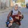 Eine Frau versucht, sich und ihr Baby vor den Kämpfen im Gazastreifen in Sicherheit zu bringen. 