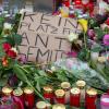 "Kein Platz für Antisemiten" steht auf einem Pappschild, das auf dem Marktplatz in Halle inmitten von Blumen und Kerzen liegt. 