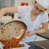 Stefanie Mayer übergießt die Lammschnitzel mit der leckern Tomaten-Paprika-Zwiebelsoße.