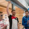 Alexander Kindig (Mitte) freut sich über seinen Sieg beim Weltcup, die Konkurrenten Artem Chernousow und Dario di Martino applaudieren.  	