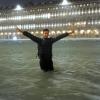 Ein Mann steht im Hochwasser auf dem überschwemmten Markusplatz.