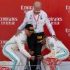 Lewis Hamilton (r) und Valtteri Bottas (l) heben Daimler-Vorstand Dieter Zetsche auf dem Podium in die Luft.