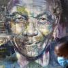 Eine Frau mit Mundschutz geht an einem Wandbild des südafrikanischen Widerstandskämpfers und ehemaligen Staatspräsidenten Nelson Mandela vorbei.