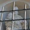 Hinter Gittern – die Albanusfigur über dem Eingangsportal zum Friedhof und zur Kirche.