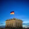 Krisenstimmung in der GroKo: Die Deutschlandfahne weht vor dem Abendhimmel auf dem Reichstag im Wind.
