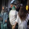 Wieder riskant: Eine Frau geht in Teheran mit offenen Haaren am Abend eine Straße entlang. Die Behörden wollen wieder stärker gegen Frauen vorgehen, die kein Kopftuch tragen. 