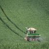 Mit dem Düngerstreuer am Traktor fährt ein Landwirt über ein noch grünes Getreidefeld. Die Preise für Stickstoffdünger steigen derzeit rasant - das trifft auch Rieser Bauern hart.