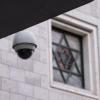 Eine Überwachungskamera hängt an einer Fassade.