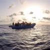 Das von der Seenotrettungsorganisation Sea-Eye herausgegebene Foto vom Mittwoch zeigt Seenotretter der «Alan Kurdi» vor einem Schlauchboot voller Flüchtlinge.