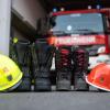 Stiefel und Helm stehen vor dem Feuerwehrhaus.