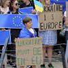 Demonstranten, die die Ukraine unterstützen, stehen mit Schildern und EU-Fahnen während einer Demonstration vor dem EU-Gipfel. 