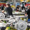 Montagemitarbeiter arbeiten im Mercedes-Benz-Werk in der Aggregateaufrüstung an Antriebssträngen für die S-Klasse.