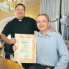 Mit einer Urkunde gratulierte Pfarrer Michael Vogg (links) seinem Kirchenmusiker Jochen Geisenberger zur bereits 15-jährigen Dienstzeit.  