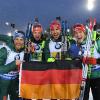 Erik Lesser (l-r-), Roman Rees, Arnd Peiffer und Benedikt Doll freuen sich mit einer deutschen Fahne über den zweiten Platz.
