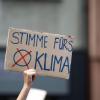 Eine Teilnehmerin hält auf der Fridays for Future-Demonstration ein Protestplakat in den Händen.