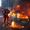 Feuerwehrleute löschen ein brennendes Auto am Rande der Ausschreitungen in Nanterre, westlich von Paris.
