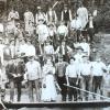 Ein Foto, das im Jahr 1908 entstand. Es zeigt Arbeiter bei Wasserbauarbeiten an der Iller. Vorne, in der Mitte des Boots ist der Wirt des Gasthauses Zur Traube, Johann Hornstein, zu sehen. 