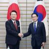 Südkoreas Präsident Yoon Suk Yeol (l.) und Japans Premier Fumio Kishida reichen sich vor ihren Gesprächen die Hände.