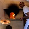 Ein Pizzabäcker holt eine Pizza aus jenem Ofen in Neapel, in dem vor 300 Jahren die erste Pizza gebacken worden sein soll. Sie war der Legende nach für Königin Margherita von Savoyen bestimmt und wurde später „Pizza Margherita“ getauft. 