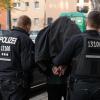 Polizeibeamte führen einen Mann nach einer Razzia in Berlin ab. Der Einsatz richtete sich gegen kriminelle Clan-Mitglieder.