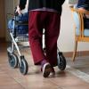 Eine ältere Frau geht mit einem Rollator über einen Flur eines Pflegeheims. 80 Prozent der Bürger fürchten den Verlust ihrer kompletten Ersparnisse, wenn sie ins Heim müssen.