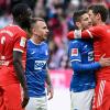 Dayot Upamecano (l) und Thomas Müller (r) von München und Angelino (2.v.l.) und Andrej Kramaric von Hoffenheim stehen nach dem Spiel auf dem Platz.