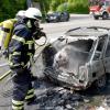 Ein Feuerwehrmann löscht den Kleinwagen auf der B28. 	