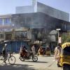 Menschen fahren an den Trümmern von Geschäften in Kundus vorbei. Die afghanische Großstadt wurde bei der Eroberung durch die Taliban stark zerstört.