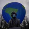 Auch EU-Gründervater Robert Schuman trägt nun Maske - hinter ihm demonstrieren Greenpeace-Aktivisten für eine bessere EU-Klimapolitik.