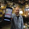 Pubbesitzer Jens Hagg präsentiert die neue App, mit der man beim Fiddler's Green in Pfaffenhofen bestellen kann.