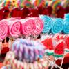 Zahlreiche bunte Lollies, auch Lutscher genannt, werden während eines Volksfestes an einem Stand zum Kauf angeboten.