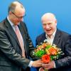 Friedrich Merz (l), CDU-Bundesvorsitzender, überreicht Kai Wegner (CDU) einen Blumenstrauß.