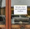 Am Fenster einer Bar in Friedrichshagen hängt ein Schild mit der Aufschrift "Wieder hier mit Freunden treffen".