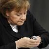 So ist sie oft zu sehen: Angela Merkel schickt gerne Kurznachrichten per Handy. Sind deren Inhalte offizieller Natur, müssen sie archiviert werden.