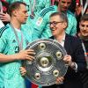 Bayerns Torhüter Manuel Neuer (l) erhält die Meisterschale.