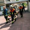 Einsatzkräfte der Feuerwehr bringen eine Trage mit Ausrüstungsgegenständen aus dem Freibad in Kulmbach (Bayern). 