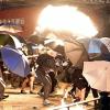 Demonstranten in der Nähe der Hong Kong Polytechnic University suchen Schutz hinter Regenschirmen.